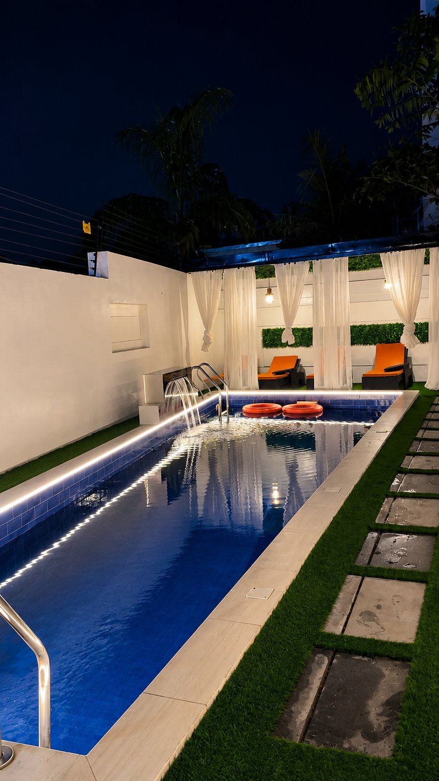 The pool after dark, lit along its edge.